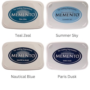 Pode incluir: Quatro almofadas de tinta para carimbar, cada uma com uma cor e um nome diferentes. As almofadas de tinta s&atilde;o brancas com um oval azul no centro. Os nomes das almofadas de tinta s&atilde;o Teal Zeal, Summer Sky, Nautical Blue e Paris Dusk.