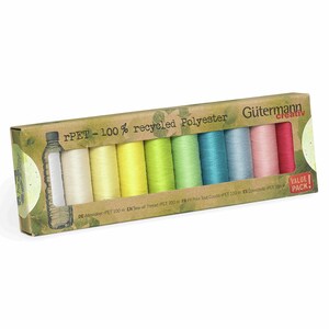 Könnte beinhalten: Ein Set von Gütermann creativ Nähgarn in einer Schachtel mit der Aufschrift "rPET - 100% recycled Polyester". Die Garnrollen sind in verschiedenen Farben wie Creme, Gelb, Grün, Blau und Rosa gehalten. Jede Rolle enthält 100 m Garn.