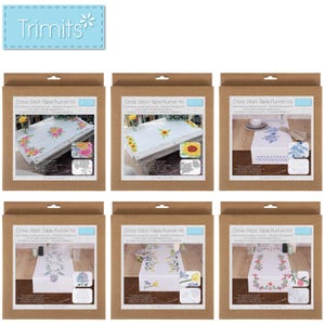 Pode incluir: Seis kits de ponto de cruz para caminhos de mesa em embalagens castanhas. Cada kit apresenta um design floral diferente num caminho de mesa branco. Os kits incluem várias cores de linha e uma agulha. O logótipo Trimits está no canto superior esquerdo.