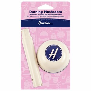 May include: White darning mushroom with a blue "H" logo and a white plastic handle. The packaging has a pink background with sewing-themed illustrations.