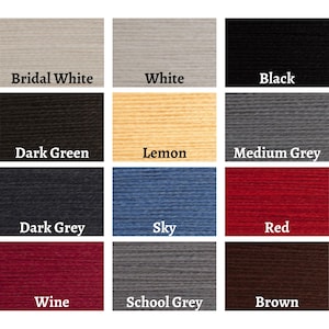 May include: A color chart featuring swatches of yarn in various shades. Colors include Bridal White, White, Black, Dark Green, Lemon, Medium Grey, Dark Grey, Sky, Red, Wine, School Grey, and Brown. Each swatch has the color name printed below.