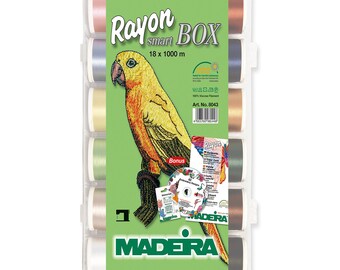 May include: A box of 18 spools of Madeira Rayon Smart embroidery thread, each spool is 1000 meters long. The box includes a bonus CD and a color card. The box is green and white with the Madeira logo. The spools are arranged in a row and are in various colors, including pink, blue, yellow, green, brown, and black.