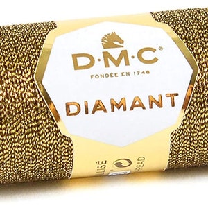 May include: A spool of gold metallic thread with the DMC Diamant label. The label features the DMC logo, the text "DMC" and "Fondee en 1746", and the word "Diamant".