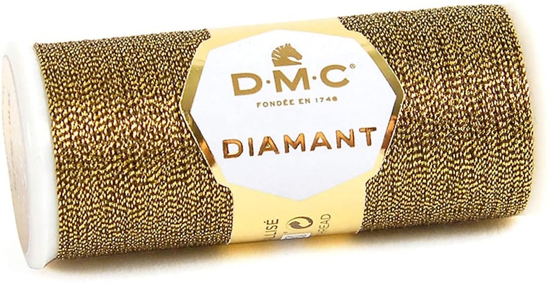 May include: A spool of gold metallic thread with the DMC Diamant label. The label features the DMC logo, the text "DMC" and "Fondee en 1746", and the word "Diamant".