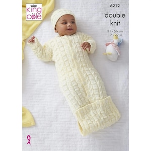 May include: A white knitted baby sleep sack with a zip down the front and a matching hat. The sleep sack has a cable knit pattern. The text "double knit" is printed on the image. The measurements 31-56 cm and 12-22 in are also printed on the image.
