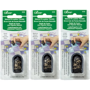 May include: Three black leather thimbles with a clover logo. The thimbles are labeled 'Small', 'Medium', and 'Large'. The packaging is green and white with the text 'Natural Fit Leather Thimble' and 'Limited Edition'.