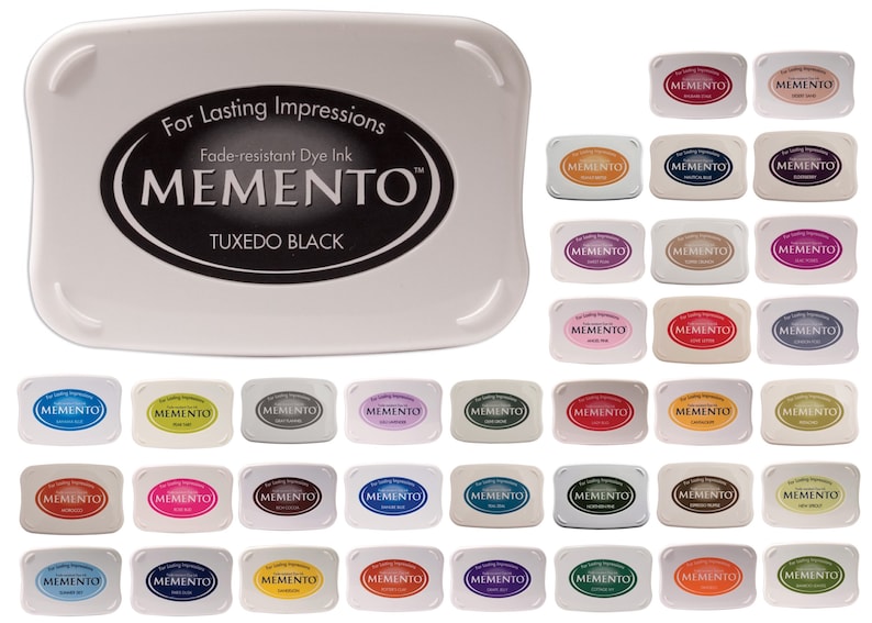 Pode incluir: Uma cole&ccedil;&atilde;o de 36 almofadas de tinta Memento em v&aacute;rias cores, incluindo Tuxedo Black, mostradas em uma disposi&ccedil;&atilde;o de grade. As almofadas de tinta s&atilde;o tinta de cor resistente ao desbotamento e s&atilde;o projetadas para impress&otilde;es duradouras.