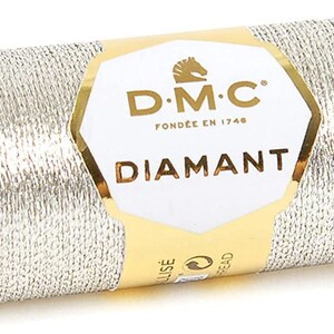 May include: A spool of silver metallic thread with a gold label that reads "DMC Diamant Fond&eacute;e en 1746".