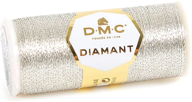 May include: A spool of silver metallic thread with a gold label that reads "DMC Diamant Fond&eacute;e en 1746".