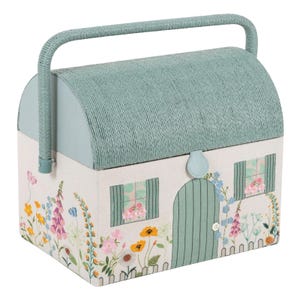 May include: A decorative cottage-shaped storage box with a woven green roof and handle. The off-white body features a floral design with a green door and windows. The box has a light blue clasp.