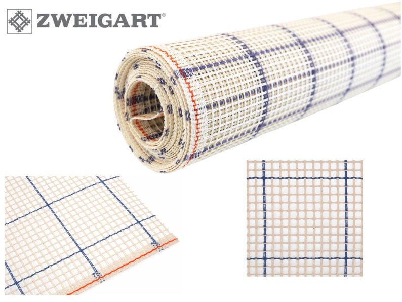 May include: A roll of white Aida cloth with blue and orange grid lines. The cloth is rolled up and the end of the roll is visible. The cloth is used for cross-stitch embroidery.
