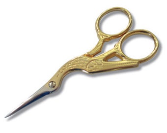 May include: Gold-coloured decorative scissors with a bird design. The scissors have a pointed tip and two loops.