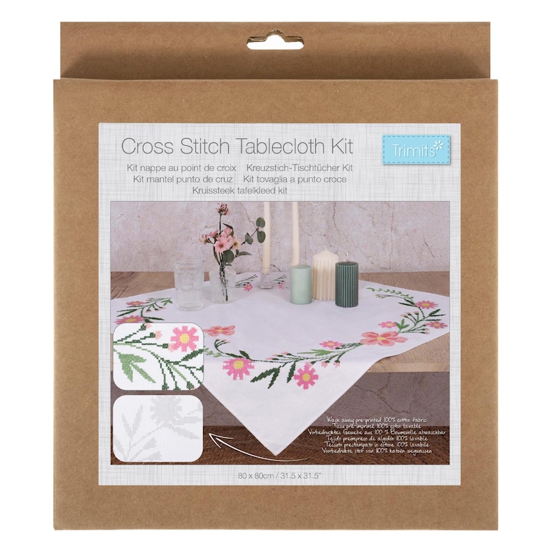 May include: A cross stitch tablecloth kit in a cardboard box. The kit includes a white tablecloth with a floral design in pink and green. The text "Cross Stitch Tablecloth Kit" is printed on the front, along with the dimensions of 31.5 x 31.5 inches.