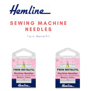 Könnte beinhalten: Zwei Packungen Hemline Twin Metalfil Nähmaschinennadeln für metallische oder Rayon-Stickgarne. Die Packung links ist für mittlere Nadeln mit 2,0 mm und die Packung rechts für mittlere Nadeln mit 3,0 mm.