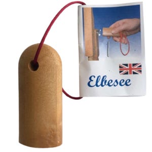 Puede incluir: Una herramienta de madera marrón claro con una parte superior redondeada y un orificio circular, conectada por un cordón rojo a una etiqueta blanca. La etiqueta muestra el texto Elbesee, una pequeña bandera británica y una ilustración.
