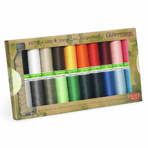 Peut inclure: Un coffret de fils à coudre Gütermann creativ de différentes couleurs. La boîte est en carton recyclé et porte la mention "rPET - 100% recycled Polyester". Chaque bobine contient 100 mètres de fil.