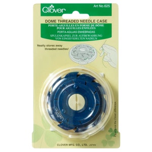 May include: A blue and white plastic dome-shaped needle case with a clear lid. The case is designed to store threaded needles. The packaging features the text "Dome Threaded Needle Case" and "Clover" branding.