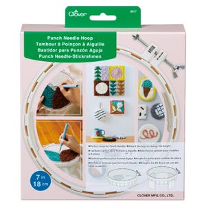 May include: A white Clover Punch Needle Hoop kit. The packaging displays a round hoop with a 7-inch (18 cm) diameter, showcasing examples of punch needle art. Text on the box includes "Punch Needle Hoop" in multiple languages.