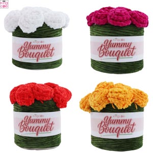 May include: Four skeins of King Cole Yummy Bouquet yarn, each featuring a dark green base and a cluster of soft, plush flowers on top in white, magenta, red, and yellow. Each label displays the text Yummy Bouquet in a decorative script font.