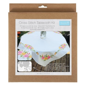 May include: A cross stitch tablecloth kit in a cardboard box. The kit includes a white tablecloth with a floral design in pink, yellow, and orange. The tablecloth measures 31.5 x 31.5 inches. The box also includes instructions.
