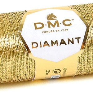 May include: A spool of gold metallic thread labeled "D.M.C. Fond&eacute;e en 1748 Diamant"