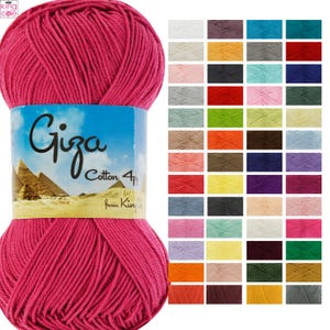 May include: A large ball of vibrant pink Giza Cotton 4 ply yarn with a label featuring the word "Giza" and pyramids. A colour chart displays various yarn colours. The yarn is from King Cole.