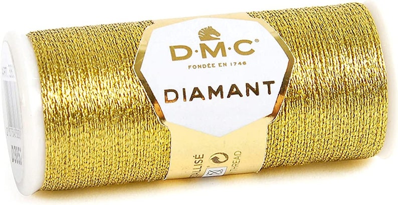 May include: A spool of gold metallic thread labeled "DMC Diamant" with a horse logo and the text "Fond&eacute;e en 1746".