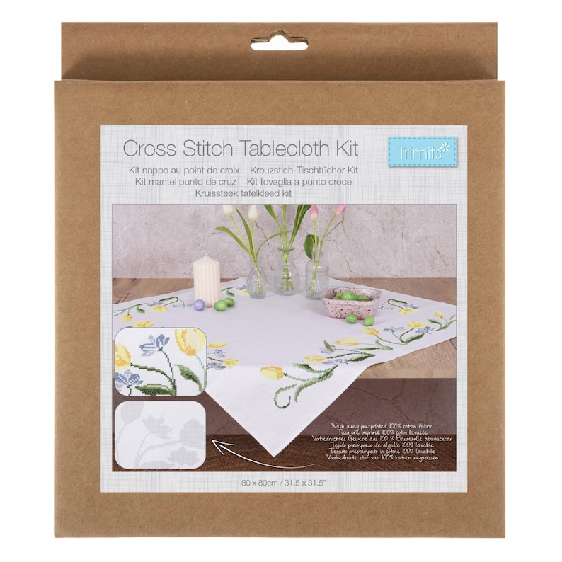 May include: A cross stitch tablecloth kit in a brown cardboard box. The kit includes a white tablecloth with a floral design, a candle, and small vases with flowers. The tablecloth measures 31.5 x 31.5 inches.