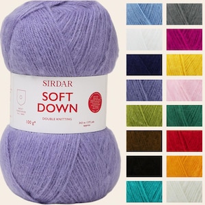 Puede incluir: Ovillo de lana lavanda Sirdar Soft Down para tejido doble. La etiqueta indica "SOFT DOWN" y "DOUBLE KNITTING". Una carta de colores muestra varios tonos de hilo, incluyendo azul, blanco, rosa, verde y rojo. Peso: 100 g.
