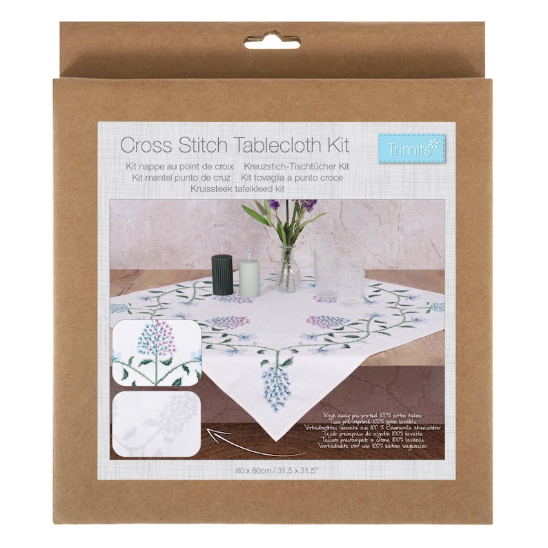 May include: A cross stitch tablecloth kit in a cardboard box. The kit includes a white tablecloth with a floral design, two sample cross-stitch patterns, and a small vase with flowers. The tablecloth measures 31.5 x 31.5 inches.