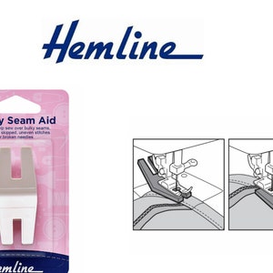May include: White plastic sewing aid tool with the text "Bulky Seam Aid" and "Hemline" on the packaging. The tool is designed to help sew over bulky seams, eliminate skipped stitches, and prevent broken needles. The packaging shows a diagram of how to use the tool.