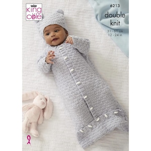 May include: A grey knitted baby sleeping bag with white buttons and a matching grey knitted hat. The sleeping bag is 31-61 cm long.