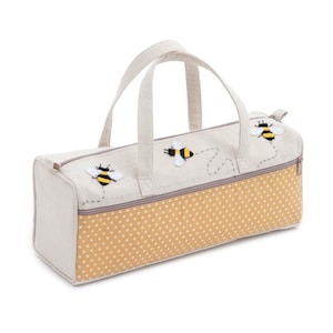 May include: A beige canvas tote bag with a yellow polka dot lining and embroidered bees. The bag has two handles and a zipper closure.