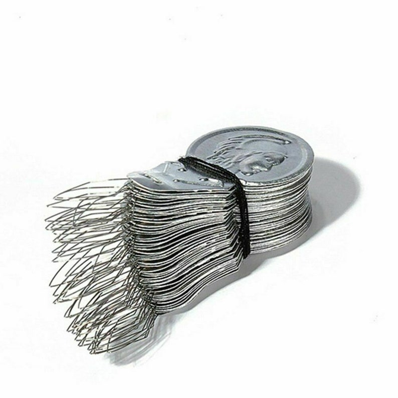 May include: A stack of silver-colored thread bobbins, each with a small metal loop at the top. The bobbins are bundled together with a black rubber band.