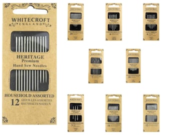 May include: A selection of Whitecroft England Heritage Premium hand sew needles. The main pack is tan and reads "Household Assorted 12". Other packs include "Quilters Between", "Tapestry/Cross-Stitch", "Easy Thread", "Tarn Darners", "Sharps/Needlemakers", "Leather Glovers", and "Embroiderers Crewel".