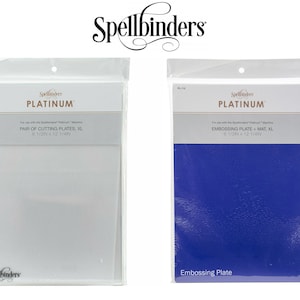 May include: Two packages of Spellbinders Platinum die cutting and embossing plates. The package on the left contains a pair of white cutting plates, labeled "PAIR OF CUTTING PLATES, XL 8 1/2" x 12 1/4" ". The package on the right contains a blue embossing plate, labeled "EMBOSSING PLATE + MAT, XL 8 1/2" x 12 1/4" ".