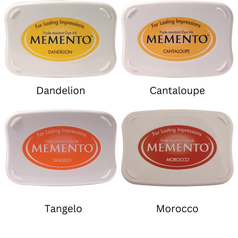 Pode incluir: Quatro almofadas de tinta para carimbar, cada uma com uma cor e um nome diferentes. As cores s&atilde;o amarelo, laranja, vermelho e marrom. Os nomes s&atilde;o Dente-de-le&atilde;o, Cantaloupe, Tangelo e Marrocos. As almofadas de tinta s&atilde;o etiquetadas com "For Lasting Impressions" e "Fade-resistant Dye Ink" com a marca "MEMENTO".