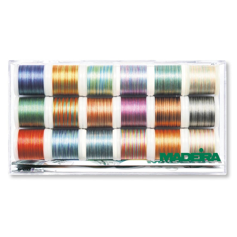 May include: A clear plastic box containing 12 spools of colorful embroidery thread. The thread is a mix of metallic and variegated colors. The box has the word "MADERA" printed on the front.