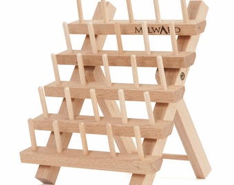 May include: A wooden thread spool holder with multiple tiers, featuring numerous pegs for organizing spools. The natural wood color and angled design provide a functional and aesthetic storage solution. The word "MILWAID" is printed on the top tier.