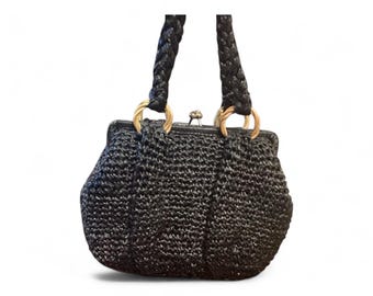 May include: Black woven handbag with braided handles and gold-tone rings. The purse has a clasp closure and a structured shape. A stylish accessory for everyday use.
