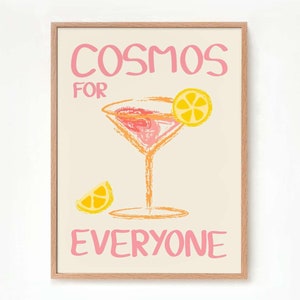 May include: A framed print with the text "Cosmos for Everyone" in pink lettering. The print features a pink and orange cocktail glass with a lemon wedge garnish.