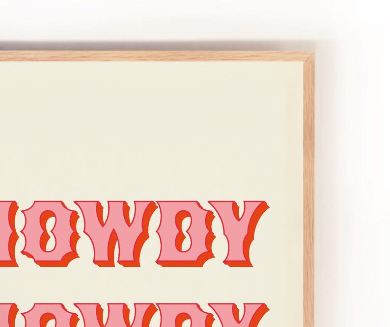 May include: A framed print with the text "Howdy" in pink and red letters on a cream background.