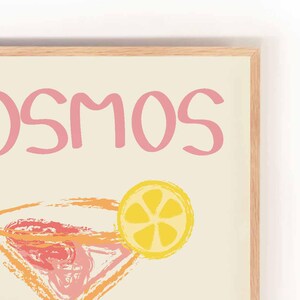 May include: A pink and yellow illustrated print with the text "COSMOS BAR" and a stylized image of a martini glass with a lemon wedge.