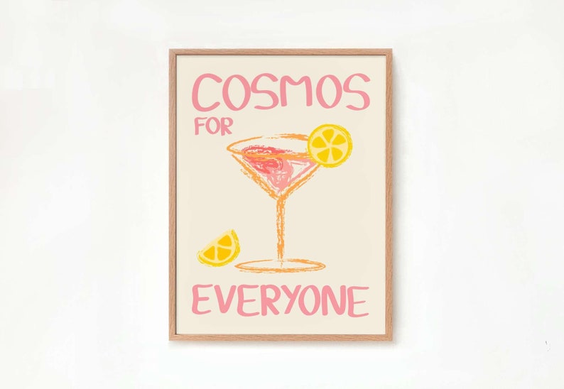 May include: A framed print with the text "Cosmos for Everyone" in pink lettering. The print features a pink and orange cocktail glass with a lemon wedge garnish.