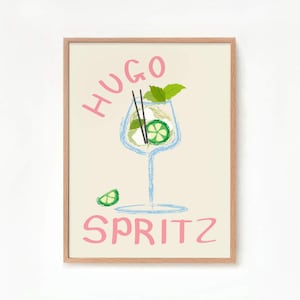 Op de afbeelding: Een ingelijst print met een lichte achtergrond met een handgetekende illustratie van een glas Hugo Spritz. De drank is afgebeeld met een lichtblauw glas, een groene limoenwig en een takje groene munt. De woorden "Hugo Spritz" zijn geschreven in roze cursief.