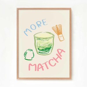 May include: A framed print with a light beige background featuring a green matcha drink in a glass, a green matcha whisk, and the text "MORE MATCHA" in pink, blue, and orange.