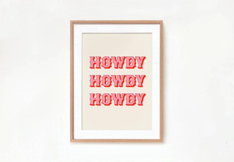 May include: A framed print with the word "HOWDY" repeated three times in a pink retro font on a cream background.