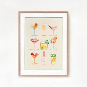 May include: A framed print of a colorful illustration of nine different cocktails, including a margarita, a mimosa, and a gin and tonic.
