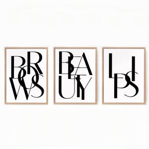 May include: Three black and white framed prints with the words "Brows", "Beauty", and "Lips" in a stylised font.