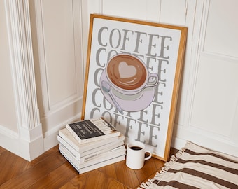 Może przedstawiać: Oprawiony wydruk artystyczny przedstawiający filiżankę kawy z sercem w pianie. Słowo "COFFEE" powtarza się w tle. Stos książek i biały kubek kawy znajdują się przed wydrukiem.